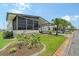 Charming single-story home featuring an enclosed porch, carport, and beautifully landscaped front yard with a palm tree at 738 Riverview Cir, North Port, FL 34287