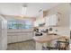 Bright kitchen featuring white cabinets, laminate counters, modern appliances, and a breakfast bar at 738 Riverview Cir, North Port, FL 34287