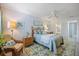 Bright bedroom featuring light blue bedding, a ceiling fan, and rattan furniture at 751 Capri Isles Blvd # 108, Venice, FL 34292