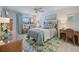 Comfortable bedroom features a rattan bed frame, blue bedding, and bright window views at 751 Capri Isles Blvd # 108, Venice, FL 34292