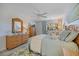 Light and airy bedroom features wicker furniture, ceiling fan, and a window letting in natural light at 751 Capri Isles Blvd # 108, Venice, FL 34292