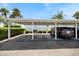 Covered carport with a parked car, surrounded by well-maintained landscaping at 751 Capri Isles Blvd # 108, Venice, FL 34292