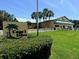 Exterior view of the clubhouse featuring palm trees and lush landscaping at 751 Capri Isles Blvd # 108, Venice, FL 34292