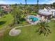 Aerial view of a community pool surrounded by lush landscaping and a sunny day at 751 Capri Isles Blvd # 108, Venice, FL 34292