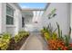 Inviting entryway featuring a glass-covered ceiling, vibrant landscaping, and a welcoming decor at 751 Capri Isles Blvd # 108, Venice, FL 34292
