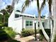 Bright white home featuring an inviting entrance with lush landscaping and soaring palm trees on a sunny day at 751 Capri Isles Blvd # 108, Venice, FL 34292
