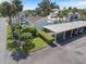 Aerial view of the property showcasing lush landscaping, carport, and outdoor patio seating area at 751 Capri Isles Blvd # 108, Venice, FL 34292
