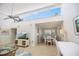 Open-concept living room with clerestory windows flowing to a dining area with white furnishings at 751 Capri Isles Blvd # 108, Venice, FL 34292