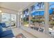 Relaxing lanai with tile flooring, overlooking the outdoor patio space with a table, chairs and a blue umbrella at 751 Capri Isles Blvd # 108, Venice, FL 34292