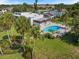 Aerial view of a pool area with lush tropical landscaping providing a serene oasis at 751 Capri Isles Blvd # 108, Venice, FL 34292