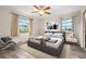 Bedroom with a ceiling fan, two windows, a gray upholstered bed, and light-colored wood-look flooring at 844 Senda Plata # 27, Venice, FL 34293