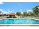 Sparkling community pool with lounge chairs, shade structures, and lush landscaping at 844 Senda Plata # 27, Venice, FL 34293