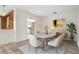 Sunlit dining area showcases a modern marble table and six chairs, complemented by neutral decor and vinyl flooring at 844 Senda Plata # 27, Venice, FL 34293