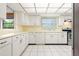 Bright kitchen with white cabinetry, tile flooring, ample counter space, and stainless steel appliances at 844 Senda Plata # 27, Venice, FL 34293