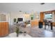 Spacious open floor plan showcases living room with wood panel accents and connected workspace with a large window view at 844 Senda Plata # 27, Venice, FL 34293