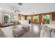 Bright living room with wood paneled accent wall, updated ceiling fan, and views of the surrounding landscape at 844 Senda Plata # 27, Venice, FL 34293