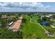 This aerial view shows a gorgeous golf course community with a large pond, green landscaping, and gorgeous condos at 849 Wexford Blvd # 849, Venice, FL 34293