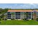 Low angle shows the condo with manicured lawn and green landscaping with some palm trees in a tropical environment at 849 Wexford Blvd # 849, Venice, FL 34293