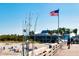 Scenic pier view featuring American flag, restaurant and beach access, offering a picturesque waterfront experience at 849 Wexford Blvd # 849, Venice, FL 34293