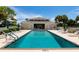 This is an exterior shot of the community pool with lounge seating, and tropical manicured grounds on a sunny day at 849 Wexford Blvd # 849, Venice, FL 34293
