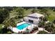 Aerial shot showcases community pool with lounge seating, manicured grounds and the building with a tile roof at 849 Wexford Blvd # 849, Venice, FL 34293