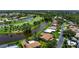Stunning aerial view of home with serene water, a golf course, and lush landscaping at 925 S Doral Ln, Venice, FL 34293