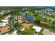 Expansive aerial view of home with inviting pool, lush landscaping, and serene water views at 925 S Doral Ln, Venice, FL 34293