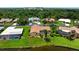 Aerial view of home featuring a screened-in pool, lush lawn, and mature trees at 925 S Doral Ln, Venice, FL 34293