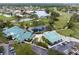 Aerial view showcasing a meticulously maintained golf course and clubhouse, surrounded by well-manicured grounds and water features at 925 S Doral Ln, Venice, FL 34293