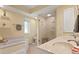 Bright bathroom with a walk-in shower, bathtub, and double sink vanity at 925 S Doral Ln, Venice, FL 34293
