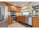 Open kitchen featuring stainless steel appliances, granite countertops and beautiful wood cabinets with an undermount sink at 925 S Doral Ln, Venice, FL 34293