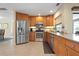 Open kitchen featuring stainless steel appliances, granite countertops and beautiful wood cabinets with neutral tile floors at 925 S Doral Ln, Venice, FL 34293
