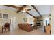 Living room featuring vaulted ceilings with wood beams, a stone fireplace and tile floors at 925 S Doral Ln, Venice, FL 34293