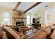 Inviting living room featuring a stone fireplace and exposed beam ceilings perfect for cozy evenings at 925 S Doral Ln, Venice, FL 34293