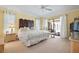 Bright main bedroom with a king-size bed and sliding glass doors to the lanai at 925 S Doral Ln, Venice, FL 34293