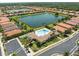 An aerial view highlights community pool with clubhouse and surrounding terracotta roofed homes and scenic lakes at 9917 Haze Dr, Venice, FL 34292