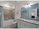 Bright bathroom featuring granite counters, a bathtub with shower, and modern fixtures at 9917 Haze Dr, Venice, FL 34292