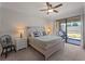 Bright bedroom featuring a ceiling fan, access to the patio, and a comfortable bed setup at 9917 Haze Dr, Venice, FL 34292