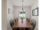 Traditional dining room featuring a wooden table, black chairs and a decorative light fixture at 9917 Haze Dr, Venice, FL 34292