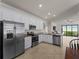 Well-lit kitchen with stainless steel appliances, granite counters, and an open layout at 9917 Haze Dr, Venice, FL 34292