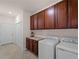 Laundry room featuring a washer, dryer, upper cabinets, and counter space at 9917 Haze Dr, Venice, FL 34292