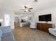 Open-concept living room featuring tile flooring, a ceiling fan, and a view into the kitchen at 9917 Haze Dr, Venice, FL 34292