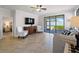 Inviting living room with a view of the screened-in patio through the sliding glass door at 9917 Haze Dr, Venice, FL 34292