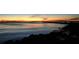 A tranquil ocean view at sunset with a distant silhouette of a pier and sailboats at 9917 Haze Dr, Venice, FL 34292
