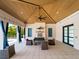 Inviting outdoor lounge area with comfortable seating, ceiling fan, fireplace, and stylish decor at 9917 Haze Dr, Venice, FL 34292