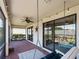 Relaxing covered patio featuring brick flooring, hanging swing, ceiling fan, and sliding glass doors at 9917 Haze Dr, Venice, FL 34292