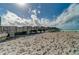 A long fishing pier stretches out over the sandy beach under a sky filled with puffy white clouds at 9917 Haze Dr, Venice, FL 34292