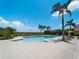 The community pool has ample lounge chairs, tables and umbrellas under blue skies at 9917 Haze Dr, Venice, FL 34292