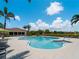 Resort style swimming pool with palm trees, lounge chairs and a clubhouse at 9917 Haze Dr, Venice, FL 34292
