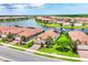 Stunning aerial view of homes on a lake in a gated community with lush landscaping and terra cotta tile roofs at 10061 Cozy Grove Dr, Venice, FL 34293